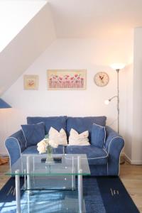 ティンヌムにあるReinhardtのリビングルーム(ガラステーブル付)の青いソファ