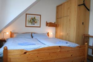 ティンヌムにあるReinhardtのベッドルーム1室(大型木製ベッド1台、枕2つ付)