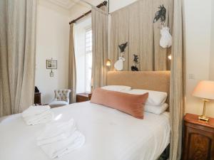 una camera da letto con un grande letto bianco e uno specchio di Derry - Mar Lodge Estate a Ballater
