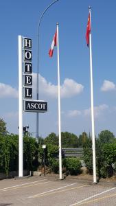 una señal de un signo razonable y dos banderas en Hotel Ascot, en Binasco