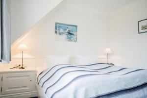 1 dormitorio blanco con 1 cama y 2 lámparas en Haus Moin, en Munkmarsch