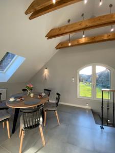 a dining room with a table and chairs and a window at Apartamenty ARNIKA z sauną zewnętrzną in Lądek-Zdrój