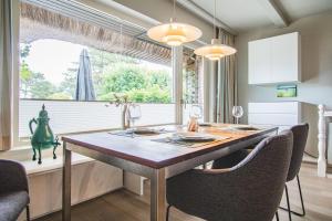 una sala da pranzo con tavolo, sedie e finestra di Haus Wattblick Meier W.U a Braderup