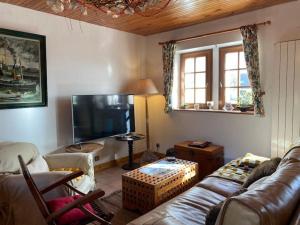 a living room with a couch and a flat screen tv at Maison de vacances 3 étoiles avec jardin à Trégastel, proche plage - FR-1-542-62 in Trégastel