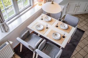 una mesa de comedor con sillas y platos. en Alte Mühle, en Keitum