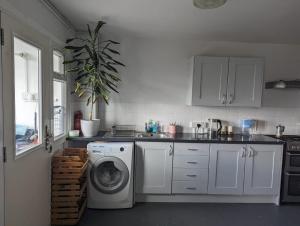 a white kitchen with a washing machine in it at Stunning 3Bed Seaview Downs National park House in Rottingdean