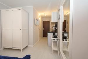 uma cozinha com armários brancos e um gato azul deitado no chão em Haus am Meer14 - App 129WB em Westerland