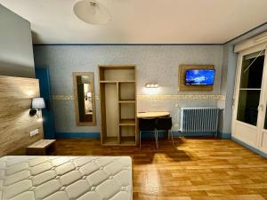 Hotel Le D'artagnan في فيك-فيزينساك: غرفة نوم بسرير وطاولة في غرفة