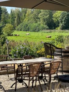 a table and chairs with a field of animals in the background at B & B De Romeinse Katzei in Borgloon
