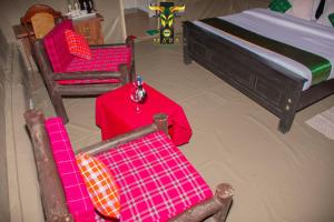 Habitación con 2 sillas, mesa y cama en Mara Olodare, en Ololaimutiek