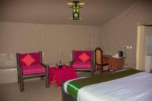 1 dormitorio con 2 sillas y una mesa en una tienda de campaña en Mara Olodare, en Ololaimutiek