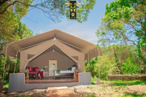 una tienda beige en medio de un bosque en Mara Olodare, en Ololaimutiek