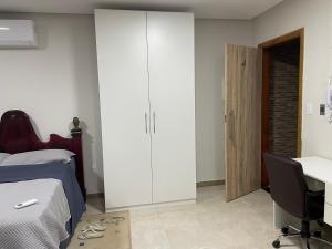 a bedroom with a bed and a desk and a cabinet at 3 Conforto próximo ao Forum in Manaus