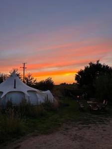 una yurta con tramonto sullo sfondo di Moat Island Glamping a Norwich