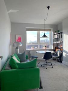 a living room with a green couch and a table at Bright flat in Stoke Newington in London