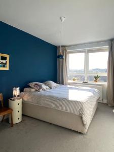 um quarto com uma cama grande e uma parede azul em Bright flat in Stoke Newington em Londres