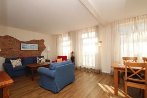 ein Wohnzimmer mit einem blauen Sofa und einem Tisch in der Unterkunft Möwennest in Westerland