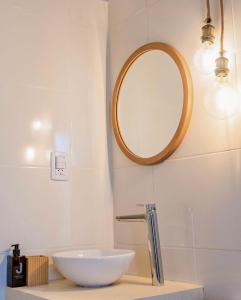 a bathroom with a white sink and a mirror at Cabañas Los Viñadores in Villa Unión