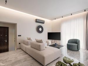 a white living room with a couch and a chair at ElKorin Jacuzzi Luxury Living in Chania