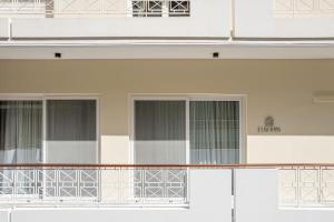 a balcony of a white building with windows at ElKorin Jacuzzi Luxury Living in Chania