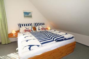 ヴェスターラントにあるThoms Hüs Knospeのベッドルーム1室(青と白の枕が備わるベッド1台付)