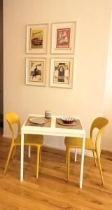uma sala de jantar com uma mesa e duas cadeiras em La Milanese - New apartment - Closed to Metrò ISOLA em Milão