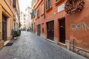 a cobblestone street in an alley between buildings at maison pelliccia in Rome