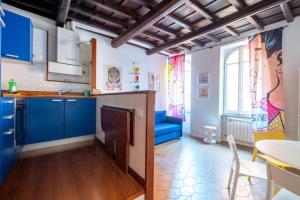 a kitchen with blue cabinets and a blue couch at maison pelliccia in Rome +3 photos