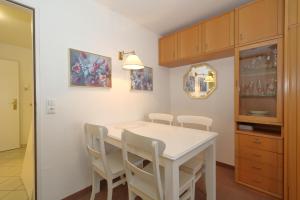 uma sala de jantar com uma mesa branca e cadeiras em Haus am Meer14 - App. 069 WB em Westerland