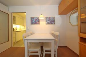 uma sala de jantar com uma mesa branca e cadeiras em Haus am Meer14 - App. 069 WB em Westerland