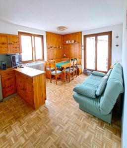 sala de estar con sofá azul y mesa en The Lovely Home en Bormio