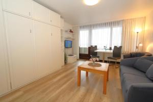 ein Wohnzimmer mit einem Sofa und einem Tisch in der Unterkunft Haus am Meer14 - App. 071 WB in Westerland