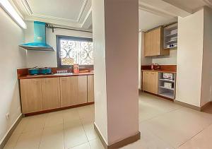 una cocina con armarios de madera y una ventana en ORION RESIDENCY BONABERIE en Duala