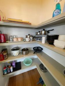 una cocina con estanterías con ollas y sartenes en Beach Cottage, en Bellerive