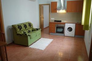 a kitchen with a green chair and a washing machine at Hotel RC Ramon y Cajal in Cuenca