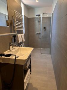 a bathroom with a sink and a shower at Hotel Schöne Aussicht in Wilhelmshaven