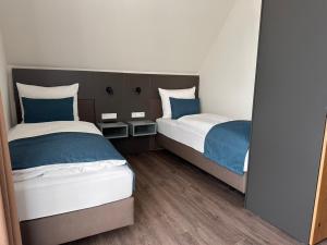 two beds in a room with blue and white at Hotel Schöne Aussicht in Wilhelmshaven