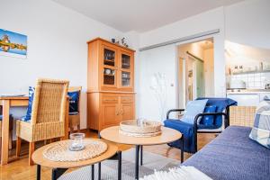 uma sala de estar com um sofá, cadeiras e uma mesa em Atlantik 23 -Standnahe Ferienwohnung em Wenningstedt