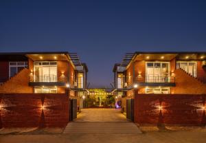 a couple of buildings with lights on them at SaffronStays Calvin - 3 Bedroom Pool Villa In Lonavala in Lonavala