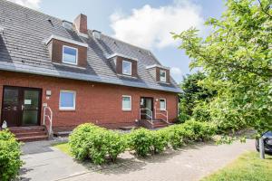 una casa de ladrillo rojo con techo de gambrel en Kiebitz-Nordseebrise - Wenningstedt, en Wenningstedt