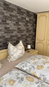 - une chambre avec un lit et un mur en briques dans l'établissement Am Sonnenberg, à Reichelsheim