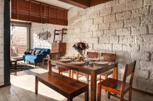 a dining room with a table and chairs and a brick wall at SaffronStays Calvin - 3 Bedroom Pool Villa In Lonavala in Lonavala