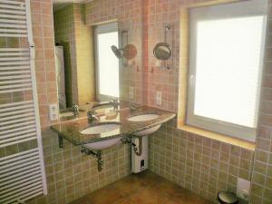 La salle de bains est pourvue de 2 lavabos et d'une fenêtre. dans l'établissement Hüs Lörki 1, à Westerland