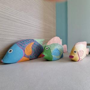 three colorful fish pillows sitting on a bed at Brezza Salentina Aparthotel in Torre San Giovanni Ugento