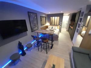 - un salon avec un lit, une table et des tabourets dans l'établissement Appartement Village Naturiste Sensuel, au Cap d'Agde