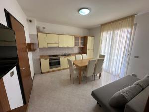 a kitchen and dining room with a table and chairs at Residence Soleil - Agenzia Cocal in Caorle