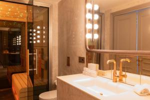 a bathroom with a sink and a mirror and a toilet at Casa Faraona Luxury Residences in Madrid