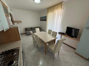 cocina y comedor con mesa y sillas en Residence Soleil - Agenzia Cocal, en Caorle