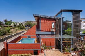 a house with a swimming pool on the roof at SaffronStays Calvin - 3 Bedroom Pool Villa In Lonavala in Lonavala