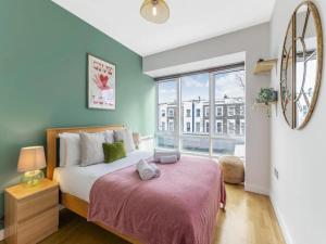 1 dormitorio con cama y ventana grande en Pass The Keys Charming 2 - Bed Apartment in Historic Drapery Modern - Comfort in Central London, en Londres
